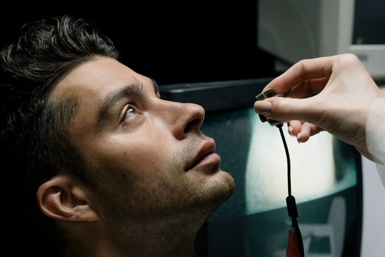 Close-up of a man in a lab setting looking up during an eye examination for medical analysis.
